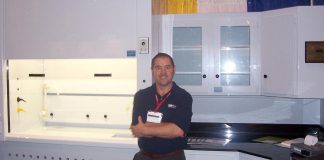 GreenUp executive director Tegan Moss's father Ric Moss, pictured with a display of custom fabricated laboratory equipment he built while working for TFI Inline circa 1998, earned his living and supported his family as a plastic fabricator. (Photo courtesy of Tegan Moss)