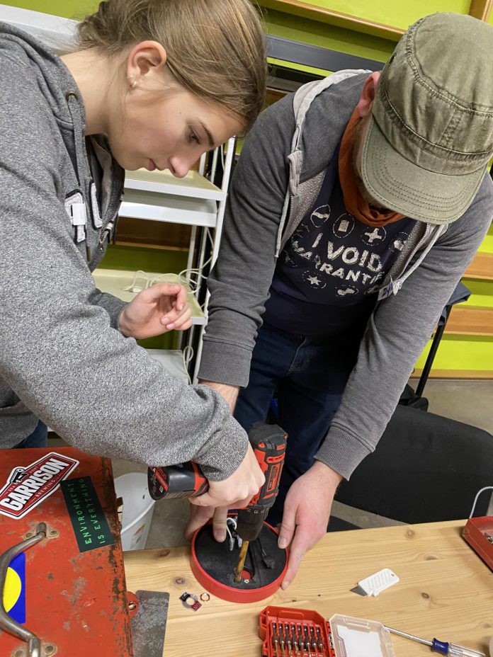 Local grade 10 student Lee Birch works with electronics fixer Dylan Radcliffe to repair a lamp and save it from landfill at January's "Fix It, Don't Trash It" climate action repair workshop for youth. (Photo: Natalie Stephenson / GreenUP)