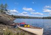 A canoe loaded with back country camping gear is pictured on Cloudy Lake in Kawartha Highlands Provincial Park. While GreenUP executive director Tegan Moss is grateful that reusable plastic food barrel enables her to comfortably camp in the back country, she recognizes that plastic's incredible versatility and durability come with a heavy cost. (Photo: Tegan Moss)