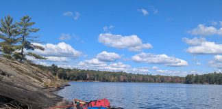 A canoe loaded with back country camping gear is pictured on Cloudy Lake in Kawartha Highlands Provincial Park. While GreenUP executive director Tegan Moss is grateful that reusable plastic food barrel enables her to comfortably camp in the back country, she recognizes that plastic's incredible versatility and durability come with a heavy cost. (Photo: Tegan Moss)