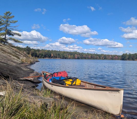 A canoe loaded with back country camping gear is pictured on Cloudy Lake in Kawartha Highlands Provincial Park. While GreenUP executive director Tegan Moss is grateful that reusable plastic food barrel enables her to comfortably camp in the back country, she recognizes that plastic's incredible versatility and durability come with a heavy cost. (Photo: Tegan Moss)