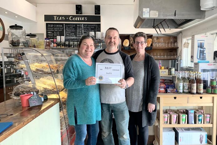 Gill and Nick Exton, owners of Stuff'd, received the award for Best Hot Chocolate from Lakefield Village Lions Club member Sandra Wren in the 2024 Hot Chocolate Festival. This year, the annual festival is now called the Lakefield Chocolate Creations Festival and has been expanded to include separate categories for food, drink, and "creative" chocolate creations. The winners of each category will be honoured as Chocolate Champions. (Photo: Lakefield Village Lions Club / Facebook)