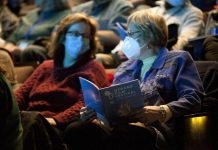 Two audience members wearing masks at the 2024 ReFrame Film Festival. Given that social justice is at the core of the ReFrame Film Festival, the festival's staff and board ensures it continues to meet the needs of the community by striving to deliver a festival that is physically, emotionally, and economically accessible as much as possible. The 2025 festival will feature more than 50 documentary films in downtown Nogojiwanong/Peterborough from January 23 to 26 and virtually from January 27 to February 2. (Photo: Esther Vincent, courtesy of ReFrame Film Festival)