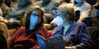 Two audience members wearing masks at the 2024 ReFrame Film Festival. Given that social justice is at the core of the ReFrame Film Festival, the festival's staff and board ensures it continues to meet the needs of the community by striving to deliver a festival that is physically, emotionally, and economically accessible as much as possible. The 2025 festival will feature more than 50 documentary films in downtown Nogojiwanong/Peterborough from January 23 to 26 and virtually from January 27 to February 2. (Photo: Esther Vincent, courtesy of ReFrame Film Festival)