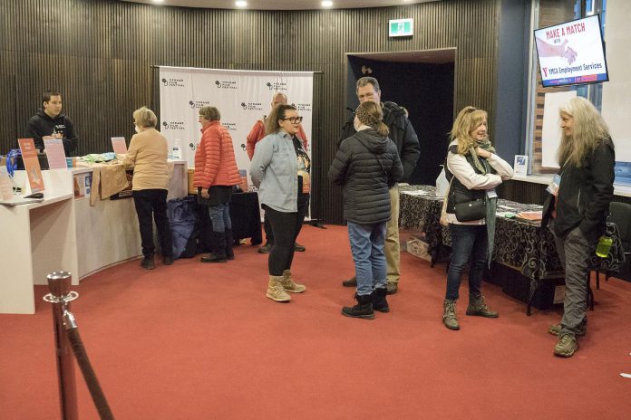 Attendees of the 2024 ReFrame Film Festival in the lobby at Showplace Performance Centre. At each film screening, festivalgoers who require fidget gadgets, sunglasses, and/or ear plugs will be able to pick up sensory kits from the lobbies of both Showplace and Market Hall Performing Arts Centre. (Photo: Esther Vincent, courtesy of ReFrame Film Festival)