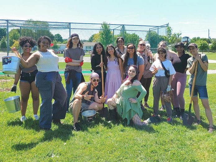 An enthusiastic group from Community Race Relations Committee of Peterborough's Resilient Roots program join volunteers from the Peterborough Community Orchard Stewards for stewardship day on May 29, 2024 at the community orchard at Keith Wightman Park in Peterborough. The group helped to water and feed the trees, spread new mulch rings around the bases, and plant raspberry canes. (Photo: Laura Keresztesi / GreenUP)