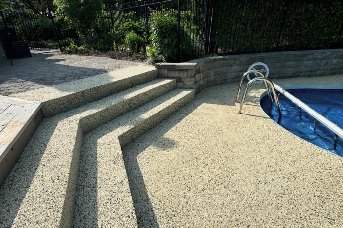 This poolside installation of Purepave highlights its seamless and slip-resistant surface designed for safety and durability. The permeable structure allows for efficient drainage, reducing water pooling while maintaining a sleek and modern look. (Photo courtesy of Horlings Garden Centre & Landscape Design and Johnston's Greenhouse & Landscaping)