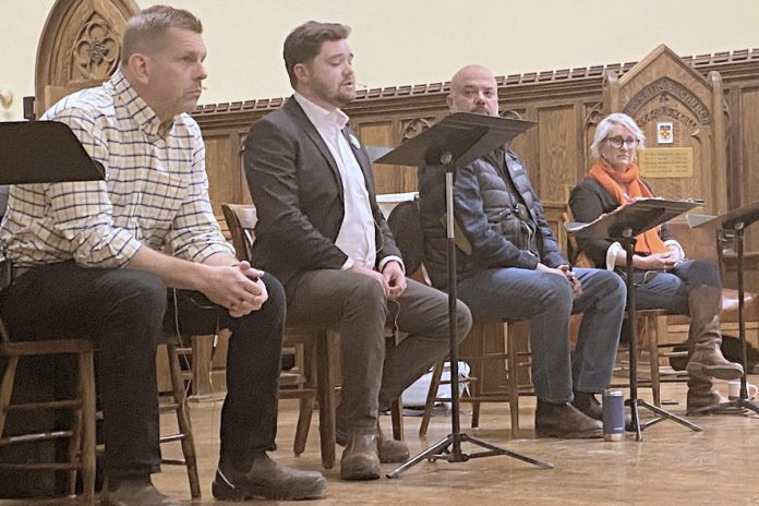 Four out of the five registered candidates for the Peterborough-Kawartha riding in the upcoming Ontario election participated in an all-candidates debate on homelessness and housing at All Saints' Anglican Church in Peterborough on February 12, 2025. Pictured from left to right are Andrew Roudly of the New Blue Party, Lucas Graham of the Green Party of Ontario, Adam Hopkins of the Ontario Liberal Party, and Jen Deck of the Ontario NDP, with an empty chair for incumbent Dave Smith of the PC Party of Ontario, who chose not to participate. (Photo: Paul Rellinger / kawarthaNOW)