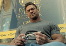 Jack Reacher (Alan Ritchson) sits on a bench in front of Pastry Peddler in downtown Millbrook in a scene from the third episode of the third season of the action-thriller series "Reacher" streaming now on Amazon Prime Video. (kawarthaNOW screenshot)