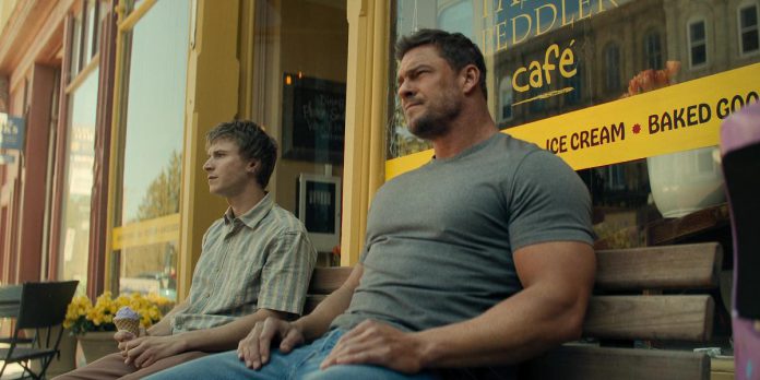 Richard Beck (Johnny Berchtold) and Jack Reacher (Alan Ritchson) sit on a bench in front of Pastry Peddler in downtown Millbrook in a scene in the third episode of the third season of the action-thriller series "Reacher" streaming now on Amazon Prime Video. (kawarthaNOW screenshot)