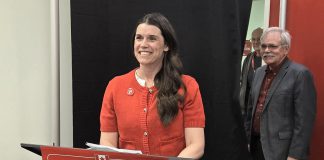 Peterborough federal Liberal candidate Emma Harrison stands at the podium as campaign manager Andy Mitchell looks on during the official launch of the Selwyn farmer and small business owner's election campaign on March 25, 2025 at the party's campaign headquarters on King Street in downtown Peterborough. (Photo: Jeannine Taylor / kawarthaNOW)