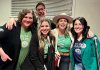 Musicians Kate Brioux, Paul Crough, Kate Suhr, Melissa Payne, and emcee Megan Murphy sport matching shirts reading "Be the Erin," as in "Be the Erin you want to see in the world," at a kitchen party fundraiser in honour of the late Erin Sullivan in March 2024. The second annual event, from which all proceeds go towards the mortgage of a home in Sullivan's name that houses people coming out of homelessness, will be held on March 14, 2025, at the Ennismore Community Centre. (Photo courtesy of Jessica Carroll)