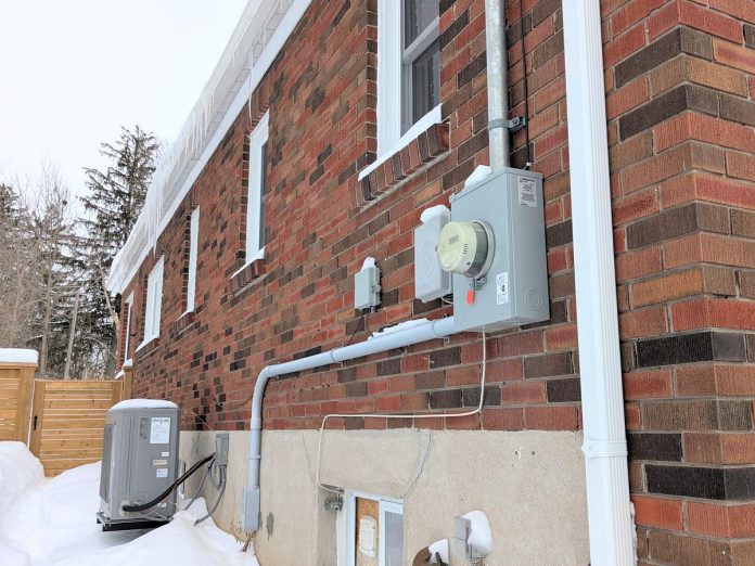 Madeleine Pengelley and David Pritchard's home in Peterborough's East City is fully powered by electricity and no longer has a connection to a gas line. The transition from gas has taken all fossil fuel combustion, and therefore all risk of carbon monoxide, out of their home. This photo shows their electricity meter and heat pump operating on a cold February morning. (Photo: Clara Blakelock / GreenUP)