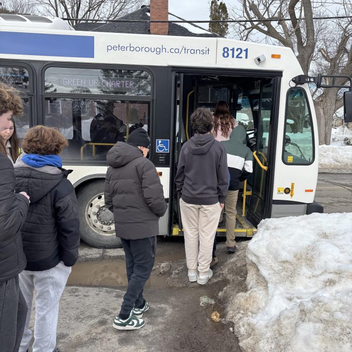 Students at Queen Mary Public School line up to board a Peterborough Transit bus brought to them as part of a transit orientation workshop offered through the Grade 8 Transit Quest program. Becoming familiar with using the transit system invites an easier transition into independent travel for young adults. (Photo: Melissa Morris / GreenUP)