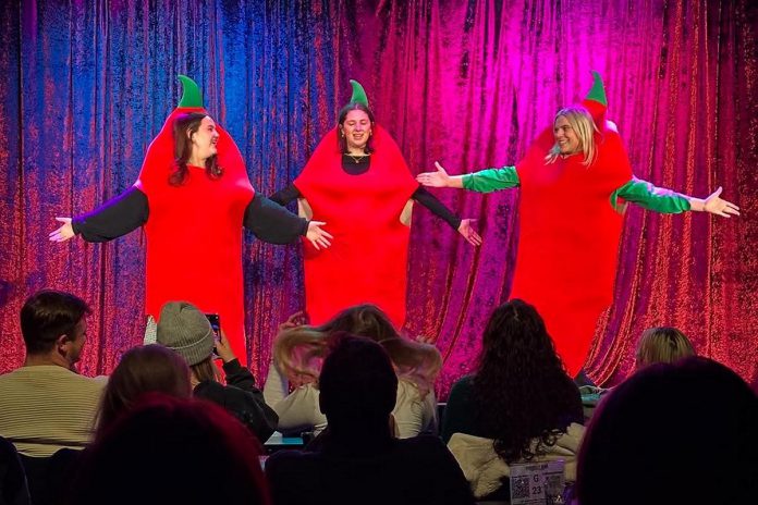 Glenna Walters, Emily Callahan, and Julia Ettlinger performing in costume as The Red Hot Sili Peppers. The trio met during a Second City improv comedy training program and in 2024 entered a sketch comedy competition called Sketch to the Death where they won the Best Newcomer Award. (Photo courtesy of The Red Hot Sili Peppers)