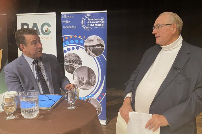 CIBC Wood Gundy advisor and portfolio manager Andrew Pyle and Armstrong Trade and Logistics Advisory Services president Bob Armstrong in discussion prior to a panel discussion at the Market Hall in downtown Peterborough on March 4, 2025. (Photo: Paul Rellinger / kawarthaNOW)