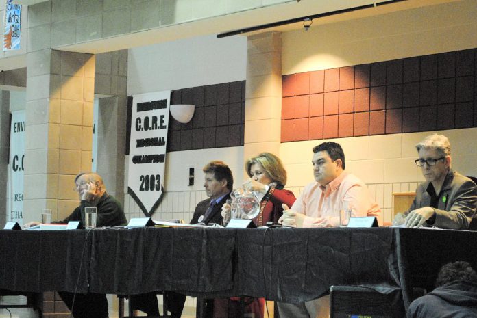 The late Dr. Elizabeth (Betsy) McGregor (pouring a glass of water) sitting beside Peterborough-Kawartha Conservative candidate Dean Del Mastro at an all-candidates debate during her first foray into federal politics in 2008. Although she came in second to Del Mastro, after a second attempt in 2011 saw her place a distant third, she decided to instead focus her attention on helping other women enter politics. (Photo via Elect Betsy McGregor Flickr account)
