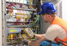 An electrician testing circuits. (Stock photo)