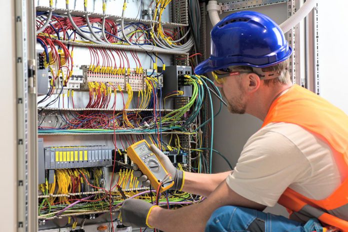 An electrician testing circuits. (Stock photo)
