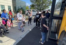 Families attending Five Counties Children's Centre's 'Ready for School' event in Cobourg in August 2024 prepare to board a school bus to see what the ride entails. Offering supports for children who may face greater challenges due to physical, developmental, or communication needs, the events are returning in Peterborough, Cobourg, and Lindsay in spring 2025 to provide families with even more time to prepare. (Photo: Five Counties)