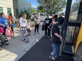 Families attending Five Counties Children's Centre's 'Ready for School' event in Cobourg in August 2024 prepare to board a school bus to see what the ride entails. Offering supports for children who may face greater challenges due to physical, developmental, or communication needs, the events are returning in Peterborough, Cobourg, and Lindsay in spring 2025 to provide families with even more time to prepare. (Photo: Five Counties)