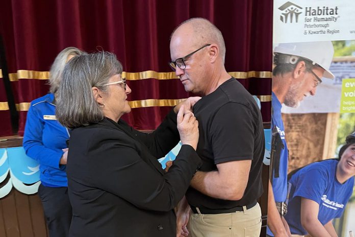 Susan Zambonin, CEO of Habitat for Humanity Peterborough & Kawartha Region (Habitat PKR), presented Lindsay ReStore volunteer Kevin Deuchars with the King Charles III Coronation Medal at a special volunteer celebration hosted at Omemee Coronation Hall on April 30, 2025 during National Volunteer Week. (Photo: Habitat PKR) Susan Zambonin, CEO of Habitat for Humanity Peterborough & Kawartha Region (Habitat PKR), presented Lindsay ReStore volunteer Kevin Deuchars with the King Charles III Coronation Medal at a special volunteer celebration hosted at Omemee Coronation Hall on April 30, 2025 during National Volunteer Week. (Photo: Habitat PKR)