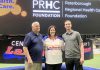 Flanked by Peterborough Century 21 Lakers board member Len Powers (left) and player Dylan Hutchison (right), Peterborough Regional Health Centre (PRHC) Foundation president and CEO Lesley Heighway dons a Peterborough Century 21 Lakers jersey at the Peterborough Memorial Centre on May 12, 2025 for an announcement of a partnership between the Lakers and the PRHC Foundation to support the $60 million Campaign for PRHC. (Photo courtesy of Peterborough Century 21 Lakers)
