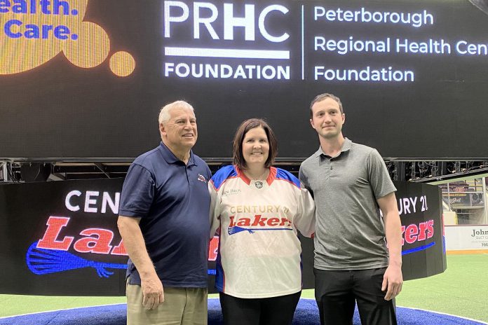 Flanked by Peterborough Century 21 Lakers board member Len Powers (left) and player Dylan Hutchison (right), Peterborough Regional Health Centre (PRHC) Foundation president and CEO Lesley Heighway dons a Peterborough Century 21 Lakers jersey at the Peterborough Memorial Centre on May 12, 2025 for an announcement of a partnership between the Lakers and the PRHC Foundation to support the $60 million Campaign for PRHC. (Photo courtesy of Peterborough Century 21 Lakers) Flanked by Peterborough Century 21 Lakers board member Len Powers (left) and player Dylan Hutchison (right), Peterborough Regional Health Centre (PRHC) Foundation president and CEO Lesley Heighway dons a Peterborough Century 21 Lakers jersey at the Peterborough Memorial Centre on May 12, 2025 for an announcement of a partnership between the Lakers and the PRHC Foundation to support the $60 million Campaign for PRHC. (Photo courtesy of Peterborough Century 21 Lakers)