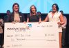 The Innovation Cluster's LevelUP program coordinator Ann-Majella McKelvie (left) and program lead Zahra Shafiei (right) present Her Yes Club founder Carmen Doucette (middle) with $10,000 after the entrepreneur won the Innovation Cluster's LevelUP Pitch Competition on April 30, 2025 at the Market Hall. One of eight graduates of the LevelUP program who pitched their business ideas to a panel of judges, Doucette created her business as a solution to her own problem of finding last-minute childcare she could trust for her own two young girls. (Photo: Bryan Reid)