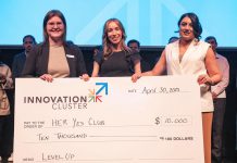 The Innovation Cluster's LevelUP program coordinator Ann-Majella McKelvie (left) and program lead Zahra Shafiei (right) present Her Yes Club founder Carmen Doucette (middle) with $10,000 after the entrepreneur won the Innovation Cluster's LevelUP Pitch Competition on April 30, 2025 at the Market Hall. One of eight graduates of the LevelUP program who pitched their business ideas to a panel of judges, Doucette created her business as a solution to her own problem of finding last-minute childcare she could trust for her own two young girls. (Photo: Bryan Reid)