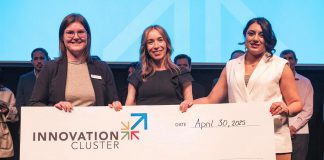 The Innovation Cluster's LevelUP program coordinator Ann-Majella McKelvie (left) and program lead Zahra Shafiei (right) present Her Yes Club founder Carmen Doucette (middle) with $10,000 after the entrepreneur won the Innovation Cluster's LevelUP Pitch Competition on April 30, 2025 at the Market Hall. One of eight graduates of the LevelUP program who pitched their business ideas to a panel of judges, Doucette created her business as a solution to her own problem of finding last-minute childcare she could trust for her own two young girls. (Photo: Bryan Reid)