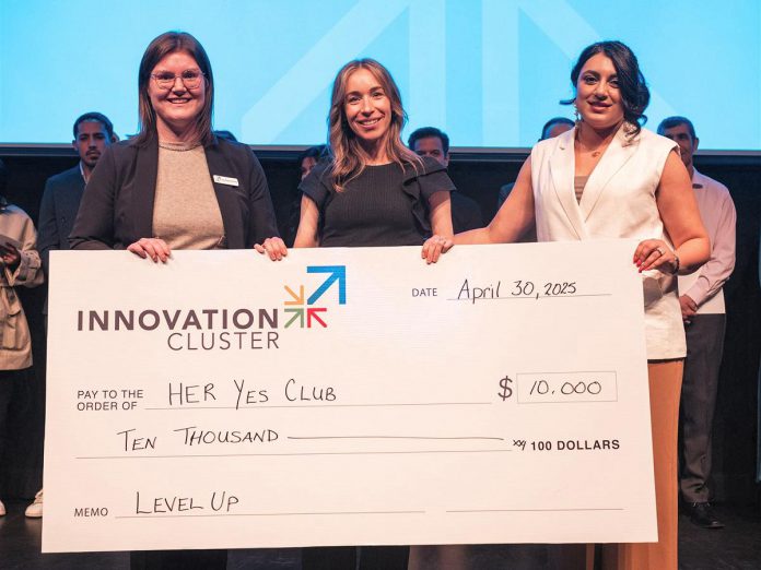 The Innovation Cluster's LevelUP program coordinator Ann-Majella McKelvie (left) and program lead Zahra Shafiei (right) present Her Yes Club founder Carmen Doucette (middle) with $10,000 after the entrepreneur won the Innovation Cluster's LevelUP Pitch Competition on April 30, 2025 at the Market Hall. One of eight graduates of the LevelUP program who pitched their business ideas to a panel of judges, Doucette created her business as a solution to her own problem of finding last-minute childcare she could trust for her own two young girls. (Photo: Bryan Reid)