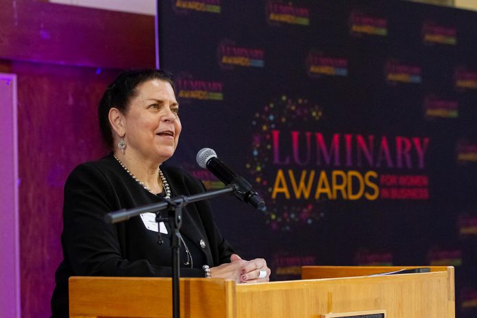 kawarthaNOW founder, CEO, and publisher Jeannine Taylor speaks at the podium at the Peterborough and Kawarthas Chamber of Commerce's inaugural Luminary Awards celebration at the Great Hall of Trent University's Champlain College on May 8, 2025 after being announced as the winner of the Legacy award. (Photo: Jordan Lyall Photography)