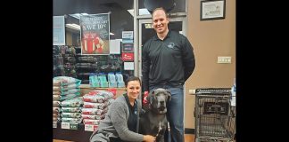 Bancroft and Bobcaygeon Pet Valu owners Nicole and Sean Courtney with their late dog Kona in the Bancroft store. Staffed with knowledgeable employees, both locally owned stores are stocked with Canadian products, offer in-store vendor demonstrations of vet-approved products, provide nail trim clinics, host events in partnership with local community organizations, and more. (Photo courtesy of Nicole and Sean Courtney)
