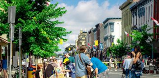 Peterborough musician VanCamp (Calvin Bakelaar) provides a soundtrack for shoppers during a summer sidewalk sale in downtown Peterborough, with the street closed to motor vehicle traffic. The Peterborough Downtown Business Improvement Area (DBIA) will be hosting Second Saturday Sidewalk Sales on June 14, July 12, August 9, and September 13, 2025. (Photo courtesy of Peterborough DBIA)