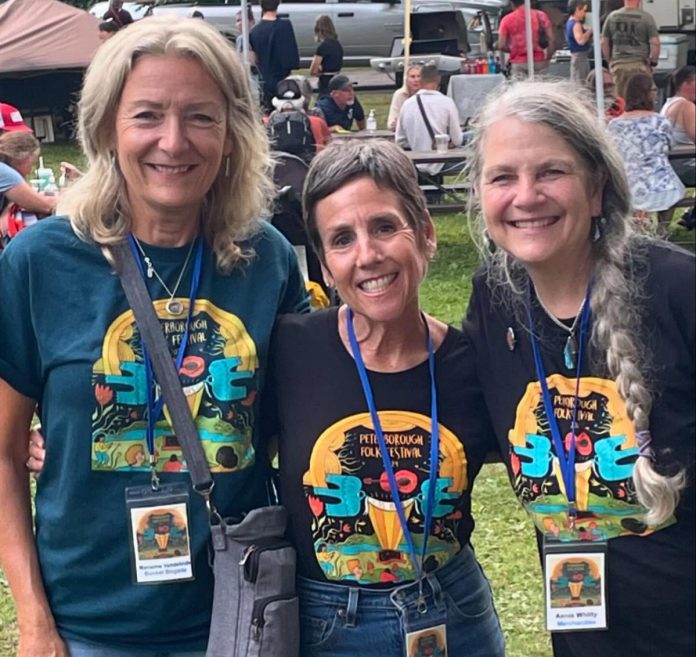 Volunteers Marianne Vandelinde, Carol Lawless, and Annie Whitty at the 2024 Peterborough Folk Festival. More than 200 volunteers help out at Nicholls Oval Park during the festival each year, along with a year-round 11-member board of directors and an artistic director. Despite the dedication of volunteers, the admission-free festival faces financial challenges from ever-increasing operational costs, including higher performer fees. (Photo courtesy of Peterborough Folk Festival)