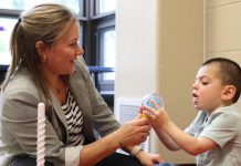 Five Counties Children's Centre occupational therapist Jess shares a smile with Five Counties client Jude during a recent treatment session. In 2024-25, Five Counties served the highest number of annual clients so far in its 50-year history, with a record 6,208 children and youth with disabilities receiving services from the regional treatment centre. (Photo: Five Counties)