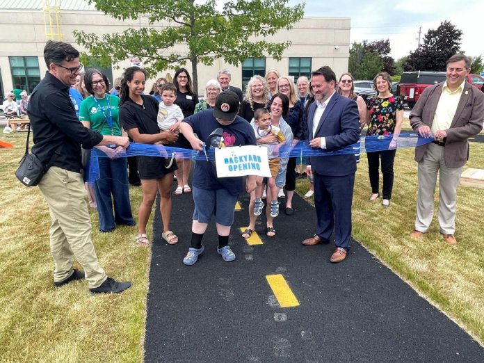 Kids, parents, families, supporters, and local dignitaries joined the celebrations at Five Counties Children's Centre in Cobourg on June 19, 2025 to mark the official opening of the new accessible backyard space. Completed at a cost of $376,000, the backyard project includes accessible amenities like a rubberized track for wheelchairs/bikes/mobility devices, sensory play equipment, a slide, and wheelchair swing, along with other play features, raised garden beds, stage area, gazebo, Indigenous cultural awareness space, sunshade cover, storage sheds, and safety fencing. (Photo courtesy of Five Counties Children's Centre) Kids, parents, families, supporters, and local dignitaries joined the celebrations at Five Counties Children's Centre in Cobourg on June 19, 2025 to mark the official opening of the new accessible backyard space. Completed at a cost of $376,000, the backyard project includes accessible amenities like a rubberized track for wheelchairs/bikes/mobility devices, sensory play equipment, a slide, and wheelchair swing, along with other play features, raised garden beds, stage area, gazebo, Indigenous cultural awareness space, sunshade cover, storage sheds, and safety fencing. (Photo courtesy of Five Counties Children's Centre)