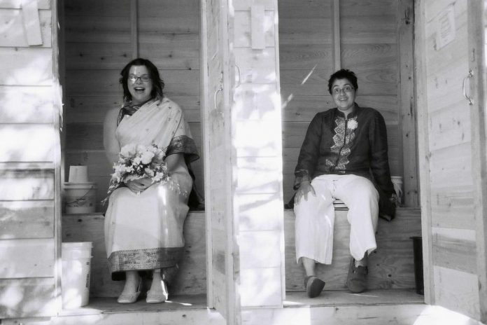 Literally and figuratively in the "out" house at their 2006 wedding on the Haida Gwaii islands in British Columbia, Peterborough healthcare professionals Sheena Howard and Vanita Lokanathan were among the first same-sex couples in Canada to be legally married. Today, the couple share why Pride Month celebrations are so important for showing solidarity and providing a safe space for LGBTQ+ people. (Photo courtesy of Sheena Howard and Vanita Lokanathan) Literally and figuratively in the "out" house at their 2006 wedding on the Haida Gwaii islands in British Columbia, Peterborough healthcare professionals Sheena Howard and Vanita Lokanathan were among the first same-sex couples in Canada to be legally married. Today, the couple share why Pride Month celebrations are so important for showing solidarity and providing a safe space for LGBTQ+ people. (Photo courtesy of Sheena Howard and Vanita Lokanathan)