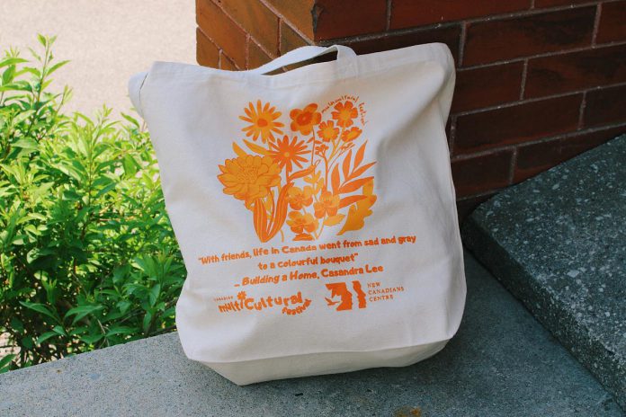 During the 2025 Canadian Multicultural Festival running from June 18 to 27, the New Canadians Centre will be selling tote bags and T-shirts bearing the festival logo. Attendees can also pick up a passport to be stamped at each attended event, and a passport with three or more stamps can be entered into a draw for the chance to win a Boro gift card that can be used at downtown Peterborough businesses. (Photo courtesy of New Canadians Centre)