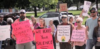 Some of the signs held by a crowd of around 75 people attending the "Rally for Integrity" outside of Peterborough City Hall on June 9, 2025, urging city councillors to hold Mayor Jeff Leal to account for breaching council's code of conduct by intimidating councillor Alex Bierk and then bullying councillor Joy Lachica as reported by the city's integrity commissioner. (Photo: Jeannine Taylor / kawarthaNOW)