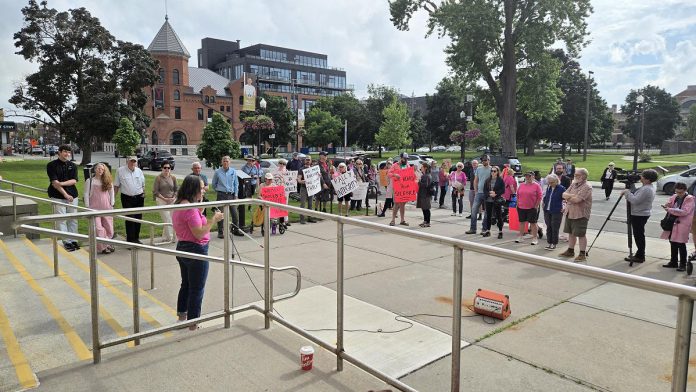 A crowd of around 75 people attended the "Rally for Integrity" outside of Peterborough City Hall on June 9, 2025, urging city councillors to change a 7-3 vote from June 2 to not penalize Mayor Jeff Leal for breaching council's code of conduct by intimidating councillor Alex Bierk and then bullying councillor Joy Lachica as reported by the city's integrity commissioner. (Photo: Jeannine Taylor / kawarthaNOW)