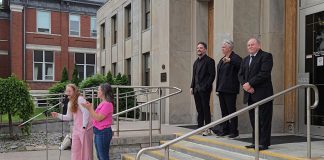 Sarah McNeilly, the sole director of Northcrest Neighbours for Fair Process (NNFP) Ltd., spoke to a crowd outside of Peterborough city hall on June 9, 2025 during the "Rally for Integrity" in support of councillors Alex Bierk and Joy Lachica (pictured with councillor Keith Riel), who the city's integrity commissioner found were intimidated and bullied by Mayor Jeff Leal. McNeilly spoke about NNFP's legal challenge against Leal's use of strong mayor powers to expedite the development of Brock Mission's proposed six-storey transitional housing building by exempting it from site plan requirements. (Photo: Jeannine Taylor / kawarthaNOW)