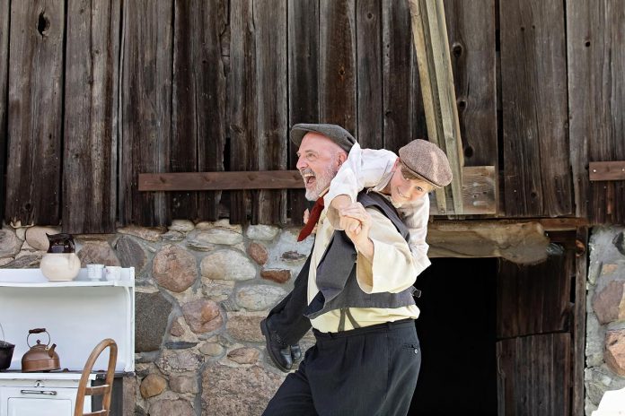 Veteran local actor Paul Crough carries Jasper Chesser in a scene from "Wild Irish Geese" at a media event at 4th Line Theatre's Winslow Farm on July 16, 2025. Making his 4th Line Theatre debut, Crough plays John Hickey, the patriarch of the Hickey family who is "fighting" for Ireland while also trying to be a good father who makes sure his family is safe and provided for. (Photo: Jordan Lyall Photography for kawarthaNO