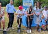 Habitat for Humanity Peterborough & Kawartha Region (Habitat PKR) and Our Daughters' Home broke ground on an accessible duplex, to be built on Sophia Street in Peterborough East City for seven adult women with developmental disabilities, on July 9, 2025. Pictured from left to right are Our Daughters' Home treasurer Debby Donaghy, Peterborough city councillor Matt Crowley, Donaghy's daughter Michelle (one of the seven women who will live in the home), Habitat PKR board chair Hope Lee, and Peterborough MP Emma Harrison with two of her children. (Photo: Bruce Head / kawarthaNOW)