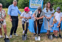 Habitat for Humanity Peterborough & Kawartha Region (Habitat PKR) and Our Daughters' Home broke ground on an accessible duplex, to be built on Sophia Street in Peterborough East City for seven adult women with developmental disabilities, on July 9, 2025. Pictured from left to right are Our Daughters' Home treasurer Debby Donaghy, Peterborough city councillor Matt Crowley, Donaghy's daughter Michelle (one of the seven women who will live in the home), Habitat PKR board chair Hope Lee, and Peterborough MP Emma Harrison with two of her children. (Photo: Bruce Head / kawarthaNOW)