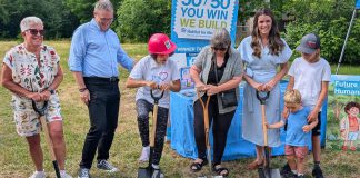 Habitat for Humanity Peterborough & Kawartha Region (Habitat PKR) and Our Daughters' Home broke ground on an accessible duplex, to be built on Sophia Street in Peterborough East City for seven adult women with developmental disabilities, on July 9, 2025. Pictured from left to right are Our Daughters' Home treasurer Debby Donaghy, Peterborough city councillor Matt Crowley, Donaghy's daughter Michelle (one of the seven women who will live in the home), Habitat PKR board chair Hope Lee, and Peterborough MP Emma Harrison with two of her children. (Photo: Bruce Head / kawarthaNOW)