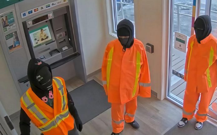 Three male suspects in the atrium of the Kawartha Credit Union branch at 4088 County Rd 121 in Kinmount on June 30, 2025. (Police-supplied photo)