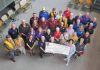 Representatives from Lions Club Districts A3 and A16 as well as 21 individual Lions Clubs from across the greater Kawarthas region presented Peterborough Regional Health Centre (PRHC) Foundation president and CEO Lesley Heighway (bottom right) with a donation of $100,000 on July 9, 2025 in support of the Campaign for PRHC and the expansion of the pediatric cancer care clinic at the regional hospital. (Photo courtesy of PRHC Foundation)
