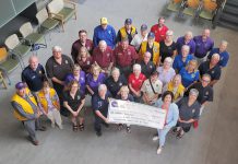 Representatives from Lions Club Districts A3 and A16 as well as 21 individual Lions Clubs from across the greater Kawarthas region presented Peterborough Regional Health Centre (PRHC) Foundation president and CEO Lesley Heighway (bottom right) with a donation of $100,000 on July 9, 2025 in support of the Campaign for PRHC and the expansion of the pediatric cancer care clinic at the regional hospital. (Photo courtesy of PRHC Foundation)